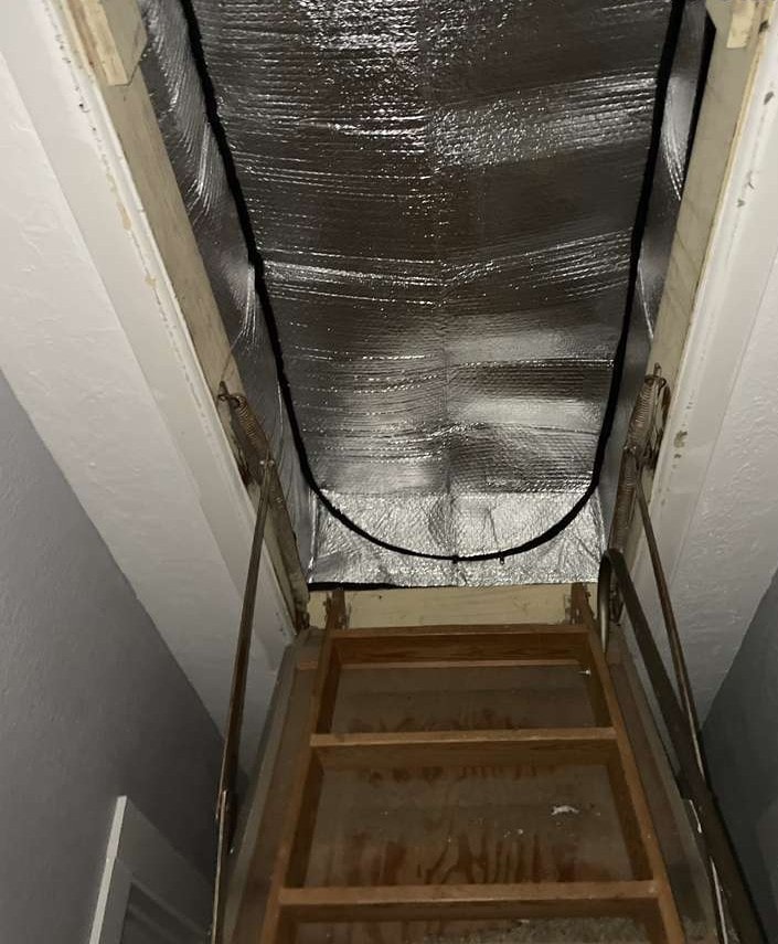Insulated foil tent installed over pull-down attic stairs to stop air leakage