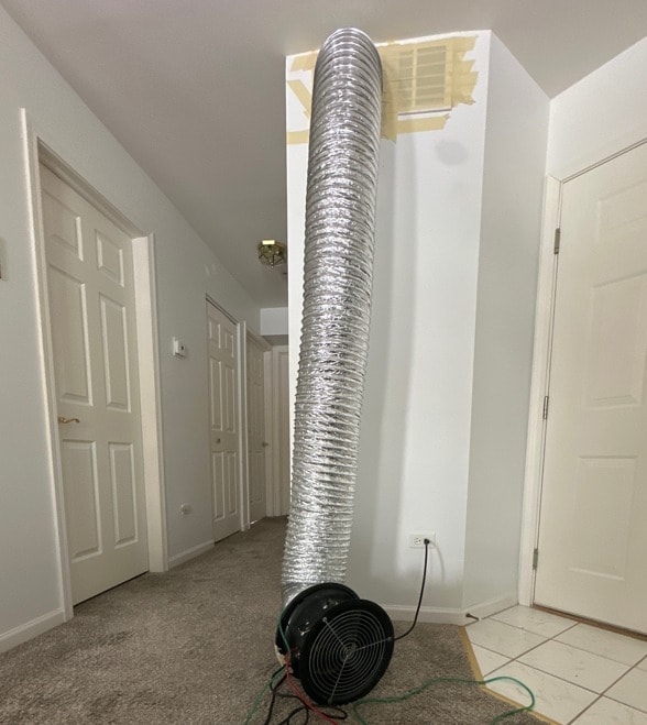 Tall flex duct rising from the duct blaster fan to a ceiling supply register